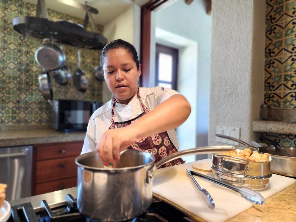 Chef Quetza stirs a pot on a stove