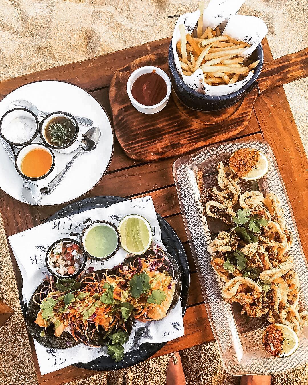 Plates of food on a board surrounded by San