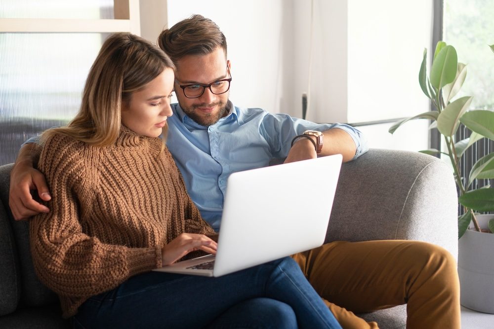 A young couple is looking through yacht charters together to pick one for their vacation.